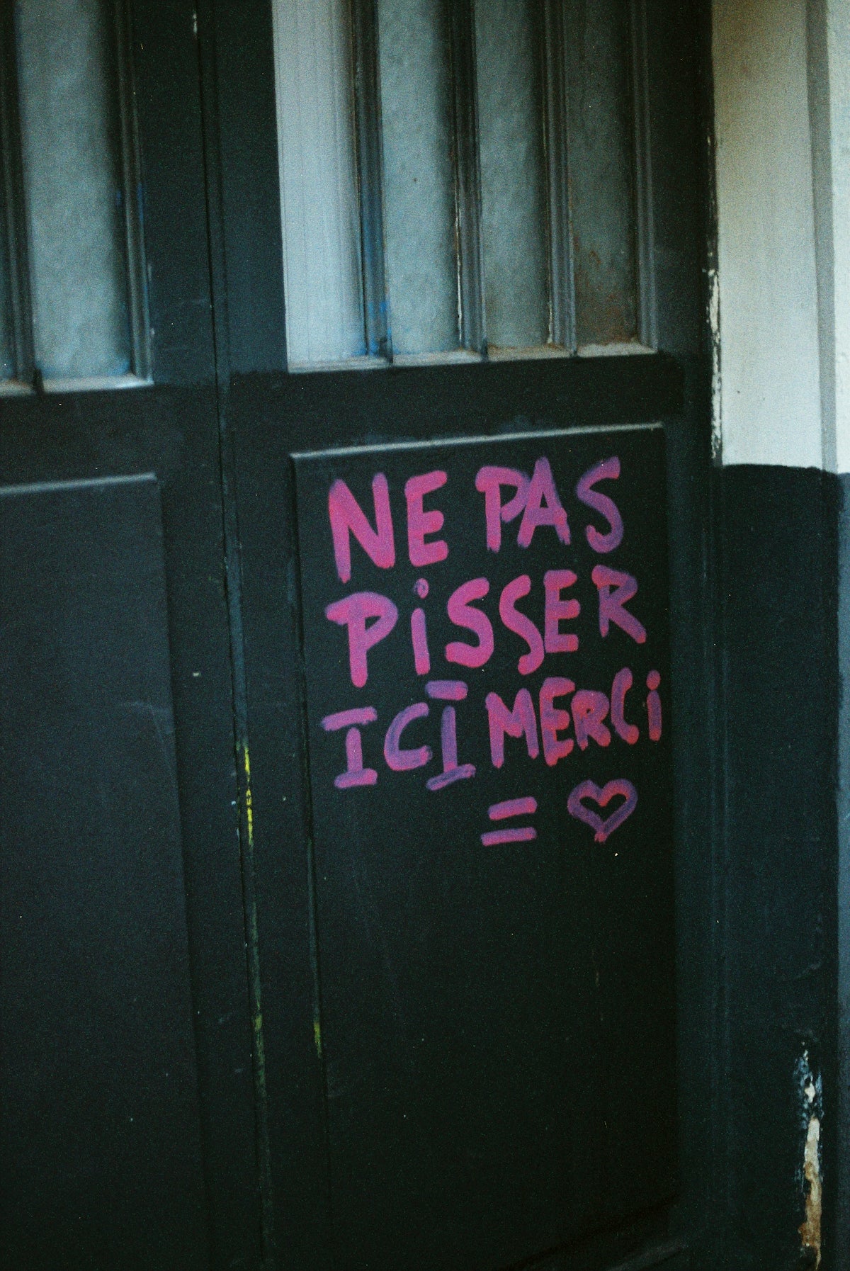 Graffiti on a door says 'do not pee here, thanks'
