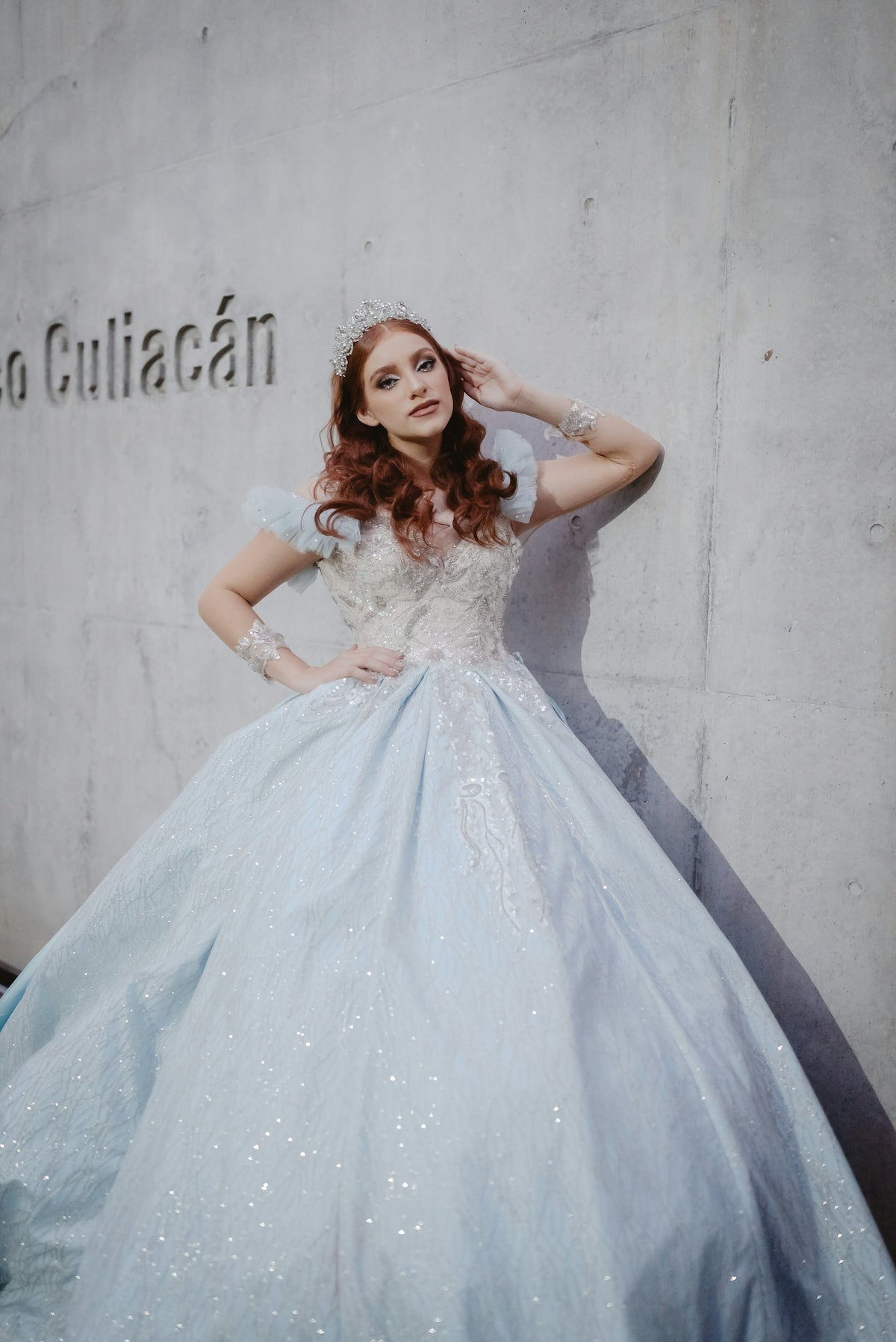 A woman in a light blue ball gown and tiara.